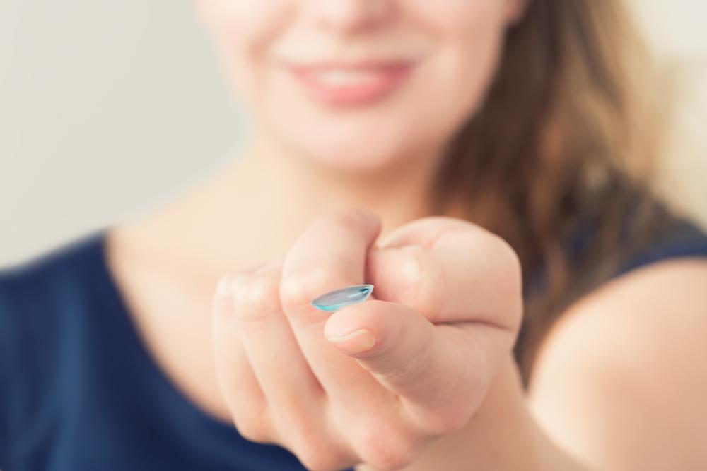 Woman holding a contact lens on her finger that she got from her eye doctor in Utica